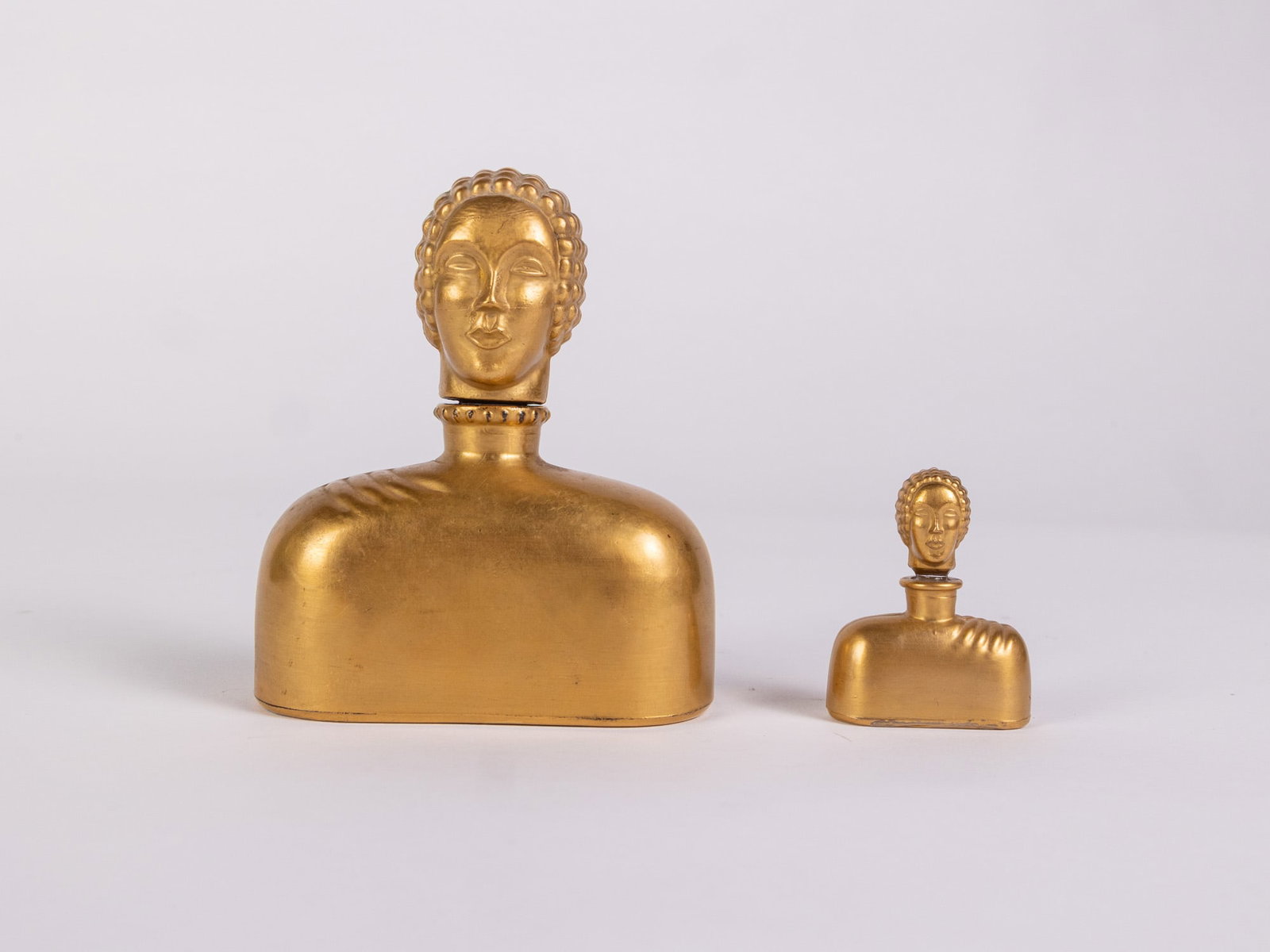 (2) Hattie Carnegie Figural Gilded Perfume Bottles: (2) Hattie Carnegie Figural Gilded Perfume Bottles: the larger bottle has a very minor chip on the stopper base which is not visible when inserted, pictured. Size 4" H Literature Brooks Auction