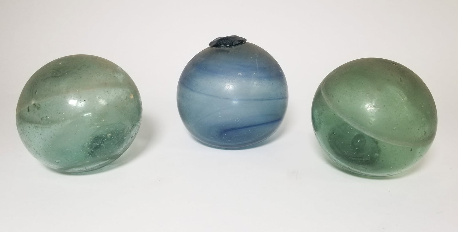 Three Hand Blown Glass Floats: Three Hand Blown Glass Floats Size 7" x 12" x 12" Literature Brooks Auction – Online Auction Terms & Conditions Contact: (856) 694-2960 | info@brooks.auction READ BEFORE YOU BID: We want you to