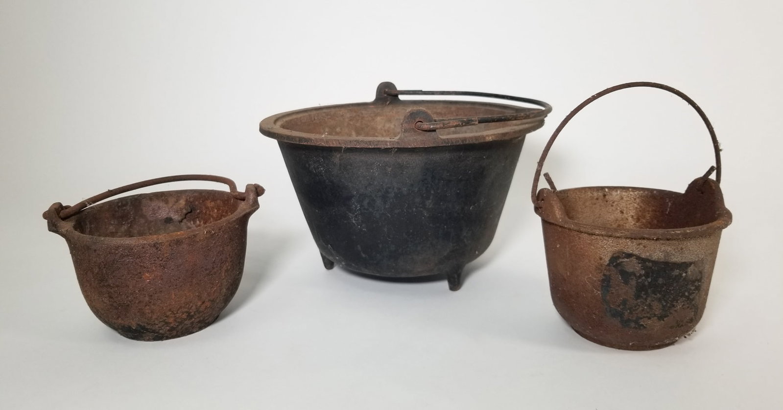 Three Cast Iron Miniature Cauldrons: Three Cast Iron Miniature Cauldrons Size 5" H Literature Brooks Auction – Online Auction Terms & Conditions Contact: (856) 694-2960 | info@brooks.auction READ BEFORE YOU BID: We want you