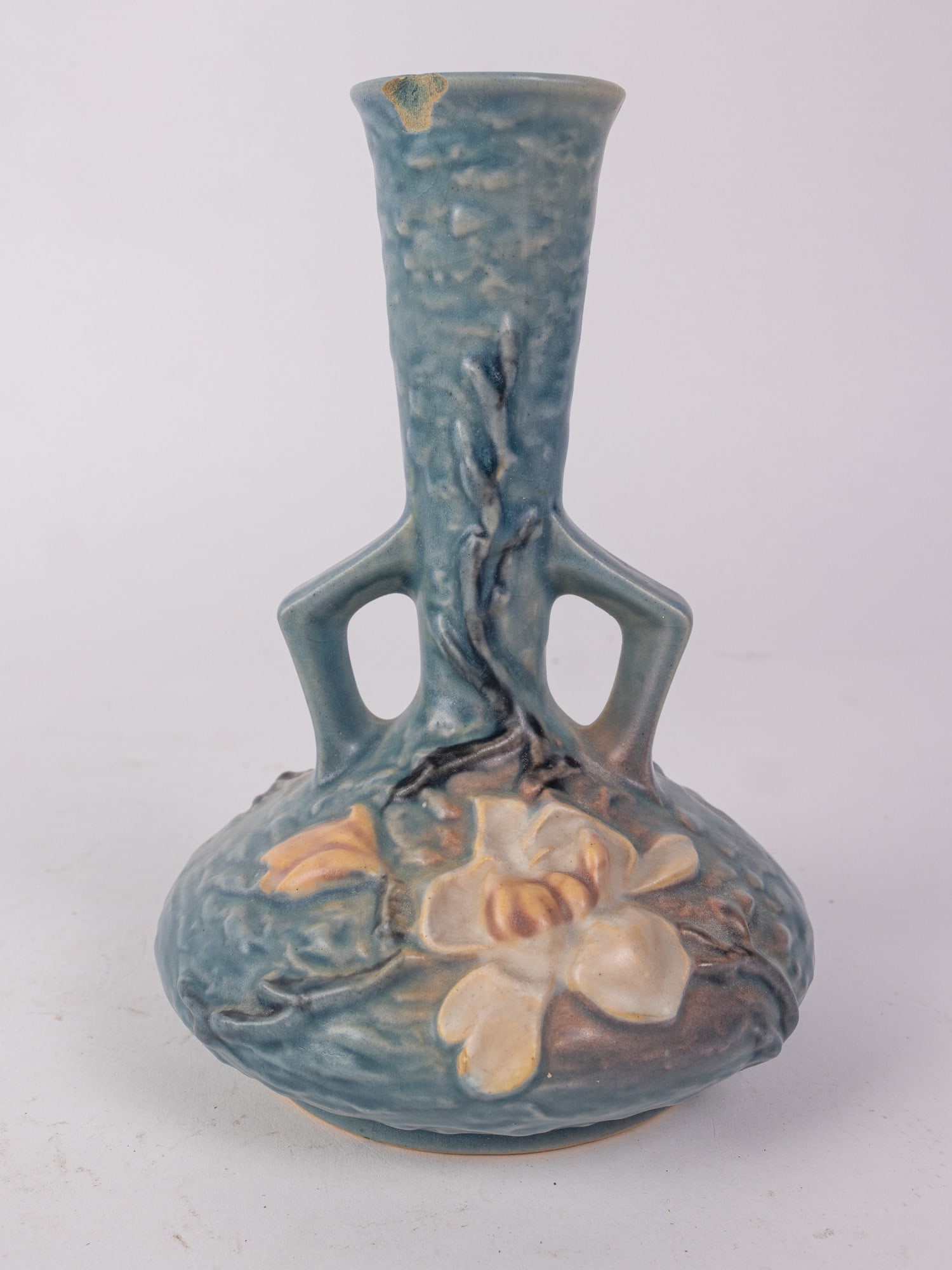 Roseville 179 7" Magnolia Vase: Chip on rim. Size 7" H Literature Brooks Auction – Online Auction Terms & Conditions Contact: (856) 694-2960 | info@brooks.auction READ BEFORE YOU BID: We want you to feel confident when
