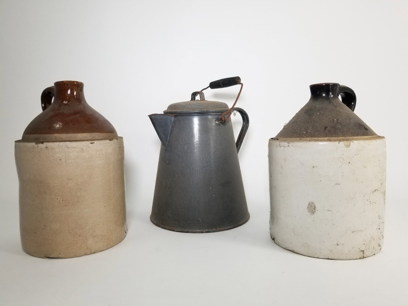 Two Stoneware Jugs and Enamelware Kettle: Two Stoneware Jugs and Enamelware Kettle Literature Brooks Auction – Online Auction Terms & Conditions Contact: (856) 694-2960 | info@brooks.auction READ BEFORE YOU BID: We want you to feel