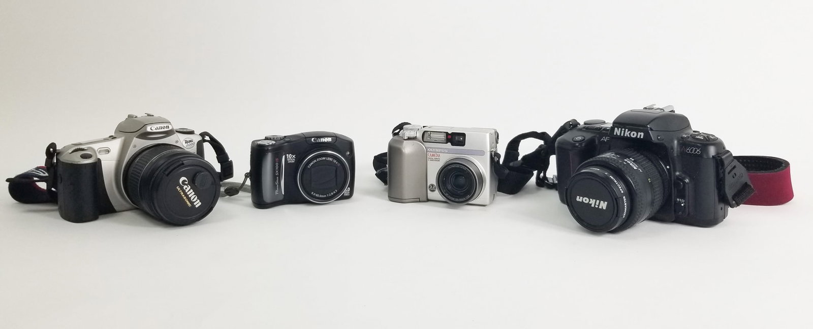 Assortment of Cameras: Canon Rebel 2000 EOS - Nikon N6006 - Olympus Camedia C-3020 - Canon Powershot SX100 IS Size 7" x 12" x 12" Literature Brooks Auction – Online Auction Terms & Conditions Contact: (856) 694-2960