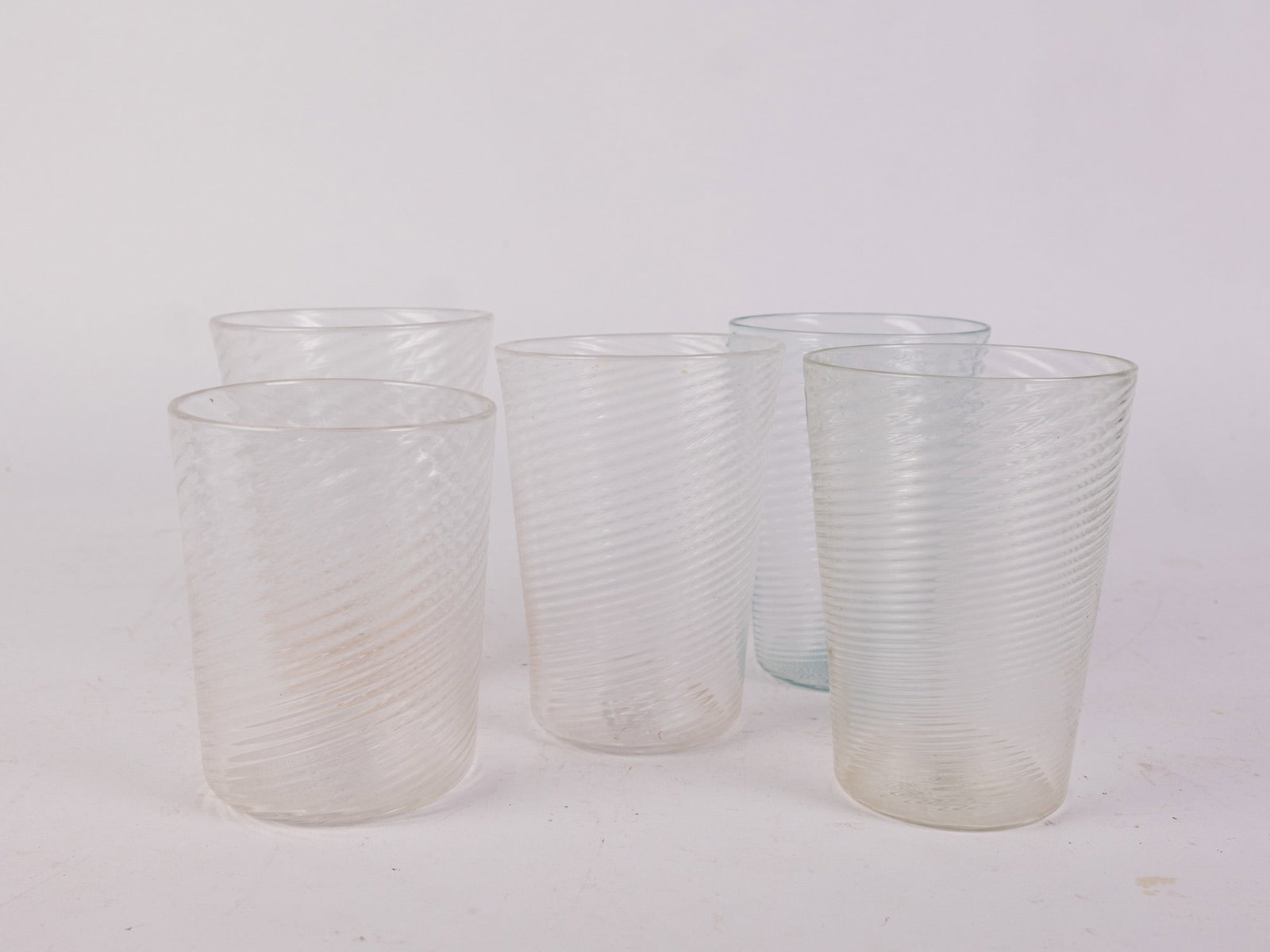 Set of Five Antique Hand Blown Ribbed Swirl Glass Tumblers: Signed on base Size 7" x 12" x 12" Literature Brooks Auction – Online Auction Terms & Conditions Contact: (856) 694-2960 | info@brooks.auction READ BEFORE YOU BID: We want you to feel confident