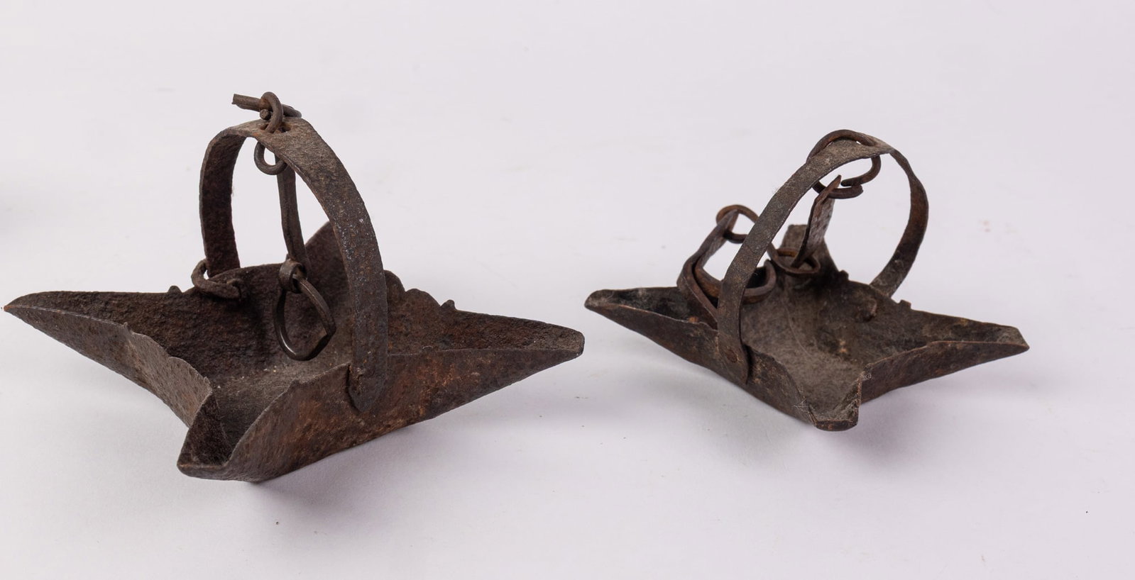 Two Early Wrought Iron Primitive Oil Lamps: Two Early Wrought Iron Primitive Oil Lamps Size 3.5" x 4" x 10" Literature Brooks Auction – Online Auction Terms & Conditions Contact: (856) 694-2960 | info@brooks.auction READ BEFORE YOU BID: