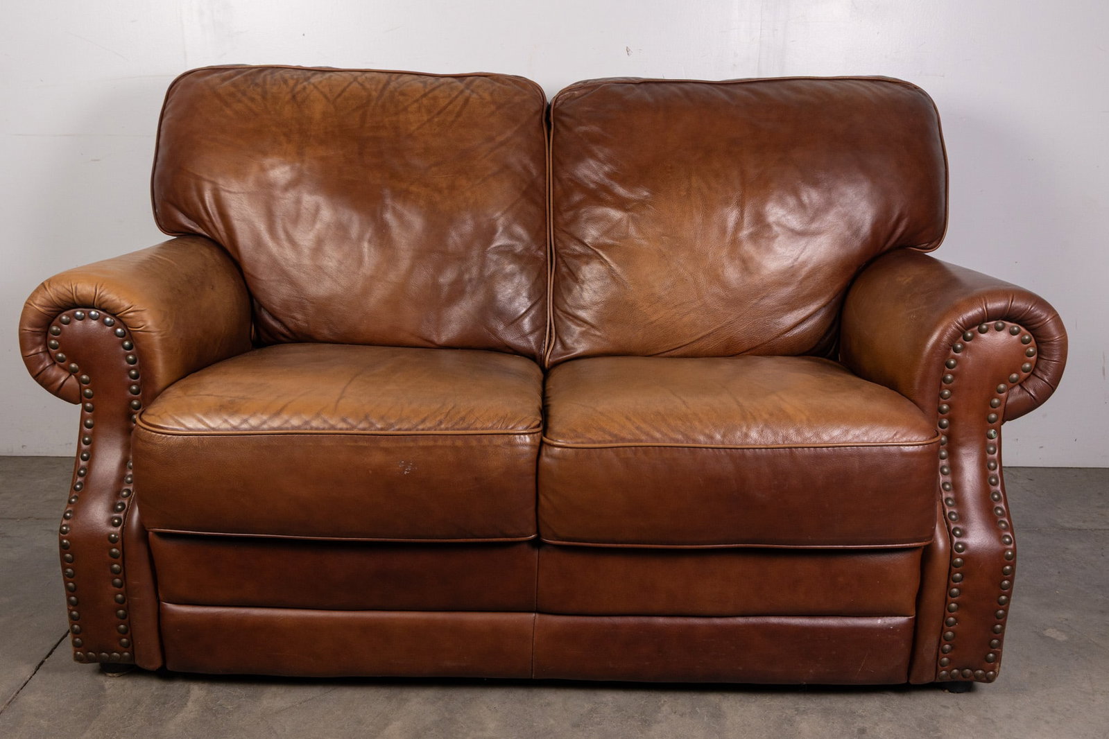 Leather Love Seat with Brass Tack Detailing: Leather Love Seat with Brass Tack Detailing Size 36" x 62" x 36" Literature Brooks Auction – Online Auction Terms & Conditions Contact: (856) 694-2960 | info@brooks.auction READ BEFORE YOU B