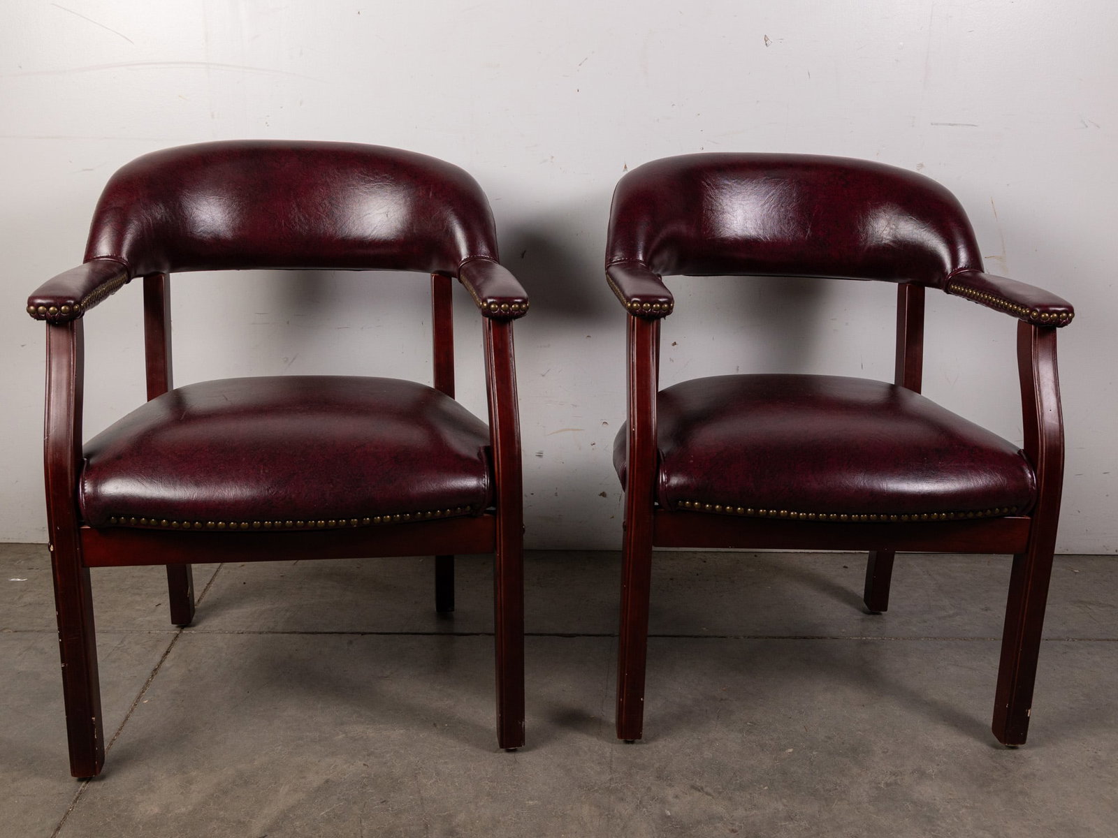 Two Contemporary Burgundy Arm Chairs with Brass Tack Accents: Two Contemporary Burgundy Arm Chairs with Brass Tack Accents Size 31" H Literature Brooks Auction – Online Auction Terms & Conditions Contact: (856) 694-2960 | info@brooks.auction READ BEFORE