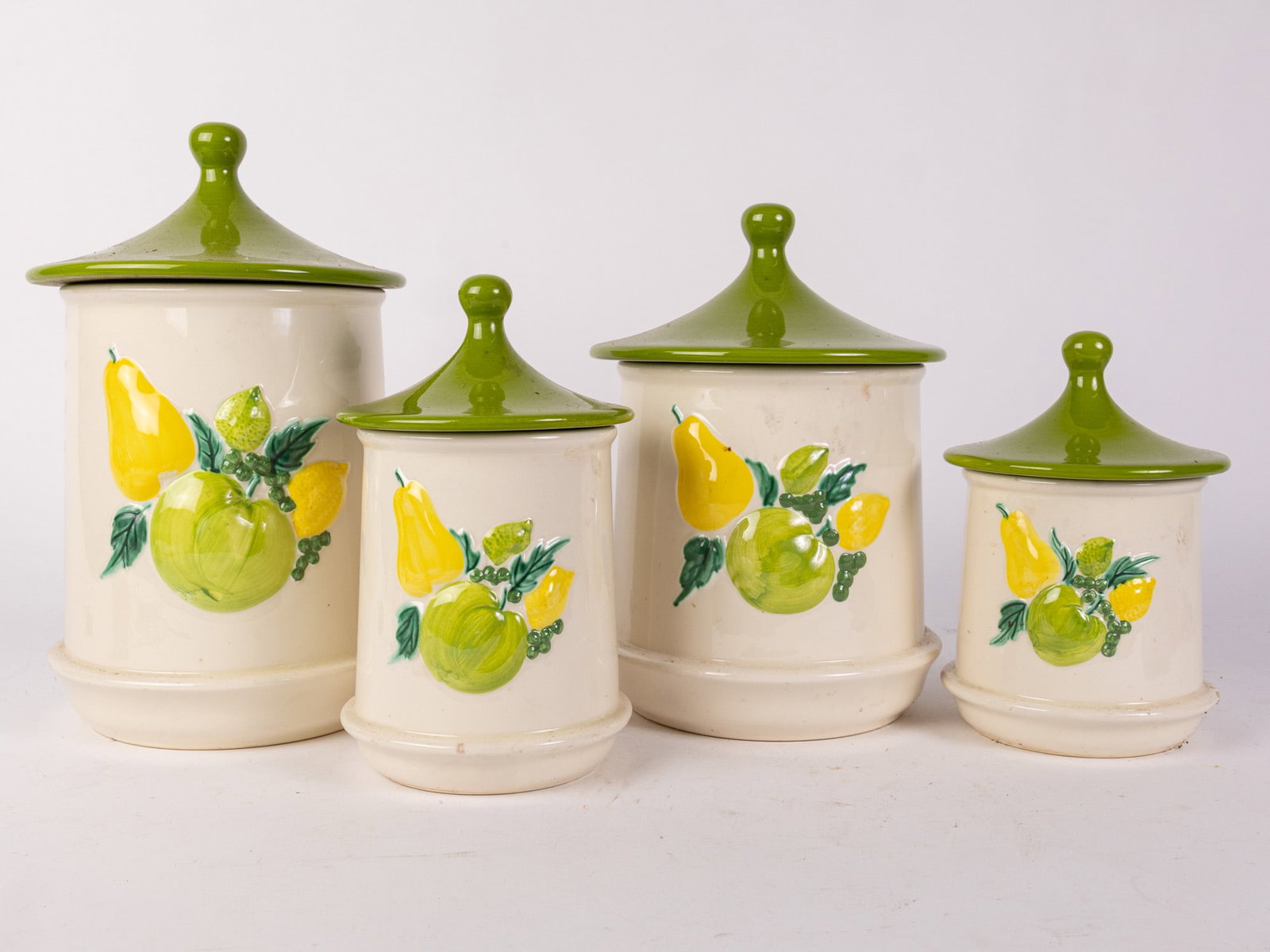 Four Piece Groovy 1970s Canister Set: The perfect vintage set to add a pop of color to your kitchen! Size 13" H Literature Brooks Auction – Online Auction Terms & Conditions Contact: (856) 694-2960 | info@brooks.auction READ BEFORE