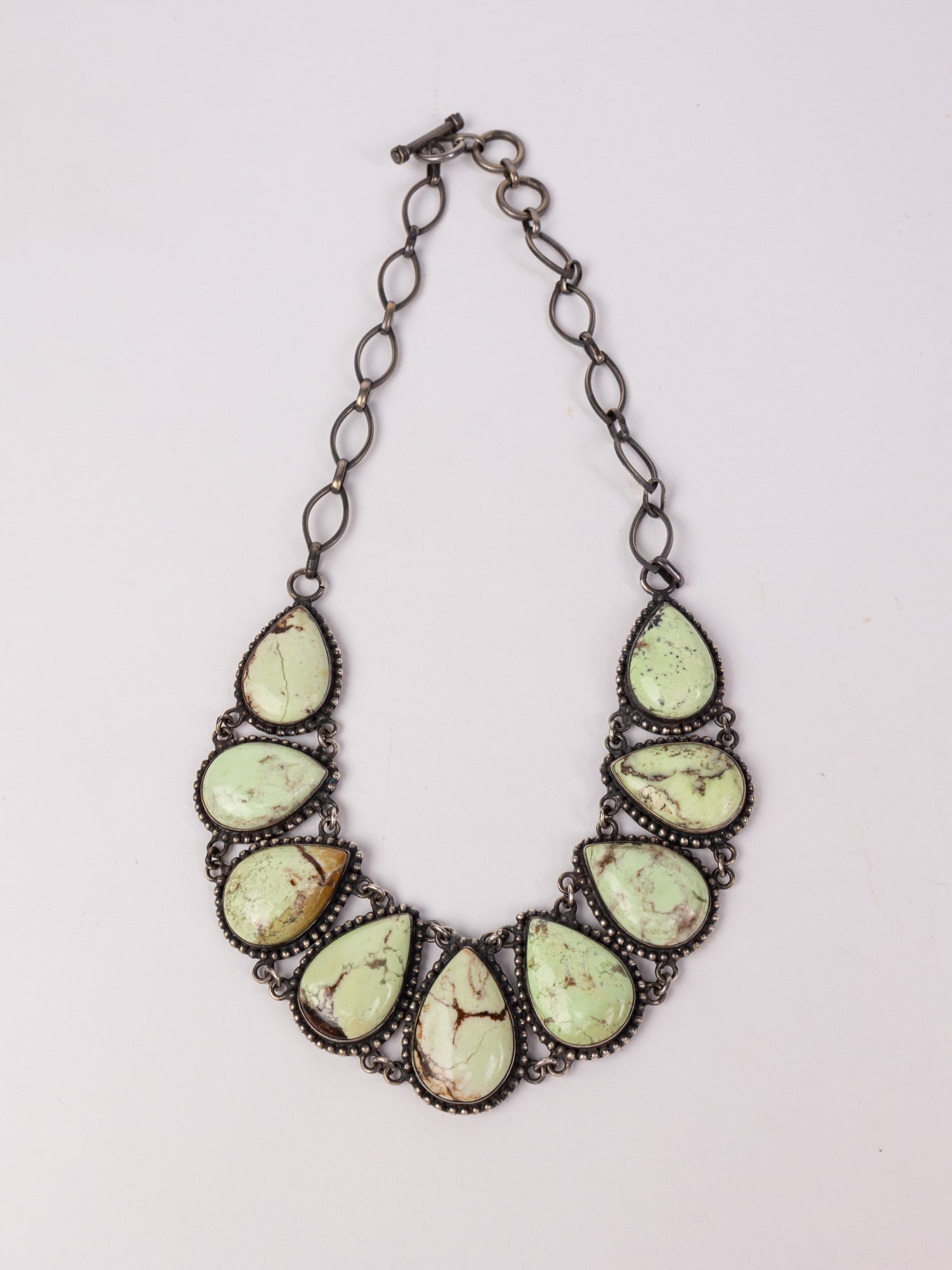 Southwest Style Sterling and Pale Green Teardrop Stone Necklace: Marked "925", Total weight is 106.6 grams Literature Brooks Auction – Online Auction Terms & Conditions Contact: (856) 694-2960 | info@brooks.auction READ BEFORE YOU BID: We want you to feel