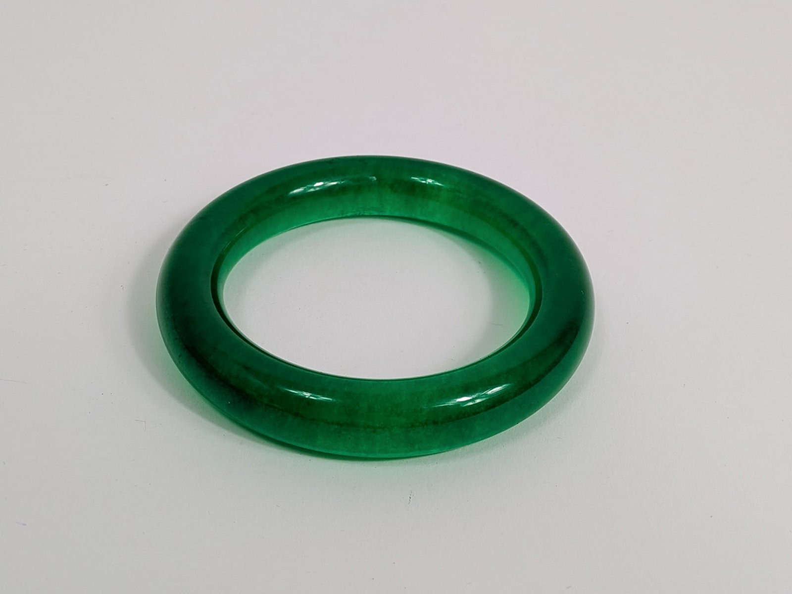 Vibrant Green Jade Bangle with Smooth Polished Finish: Vibrant Green Jade Bangle with Smooth Polished Finish Literature Brooks Auction – Online Auction Terms & Conditions Contact: (856) 694-2960 | info@brooks.auction READ BEFORE YOU BID: We want