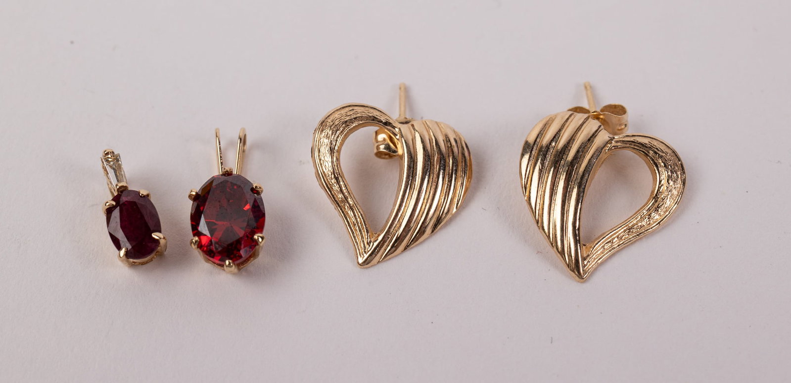 14KY Pair of Earrings and Two Pendants with Red Stones: Marked "14K", Total weight is 1.8 grams Literature Brooks Auction – Online Auction Terms & Conditions Contact: (856) 694-2960 | info@brooks.auction READ BEFORE YOU BID: We want you to feel