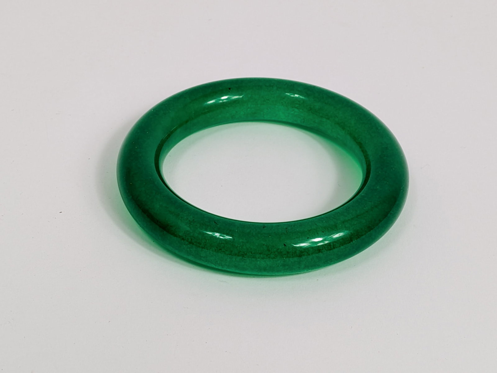 Vibrant Green Jade Bangle with Smooth Polished Finish: Vibrant Green Jade Bangle with Smooth Polished Finish Literature Brooks Auction – Online Auction Terms & Conditions Contact: (856) 694-2960 | info@brooks.auction READ BEFORE YOU BID: We want