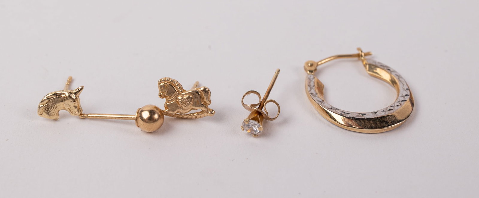 Grouping of 14KY Gold Earrings: Marked "14KT", Total weight is .9 grams Literature Brooks Auction – Online Auction Terms & Conditions Contact: (856) 694-2960 | info@brooks.auction READ BEFORE YOU BID: We want you to feel