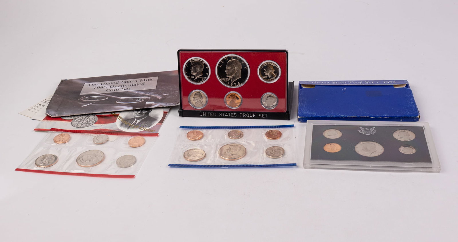 Three Vintage United States Coin Sets: Includes proof sets for the years 1972 and 1973 and a 1996 Uncirculated Coin Set. Literature Brooks Auction – Online Auction Terms & Conditions Contact: (856) 694-2960 | info@brooks.auction