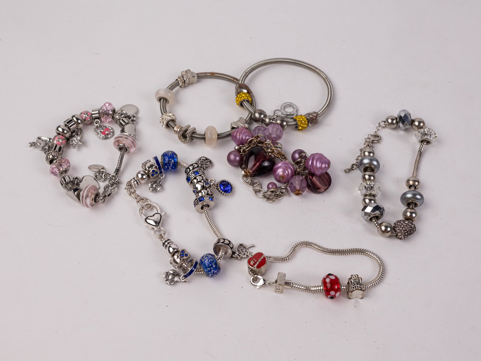Assortment of Silver-Tone Charm Bracelets: Assortment of Silver-Tone Charm Bracelets Literature Brooks Auction – Online Auction Terms & Conditions Contact: (856) 694-2960 | info@brooks.auction READ BEFORE YOU BID: We want you to feel