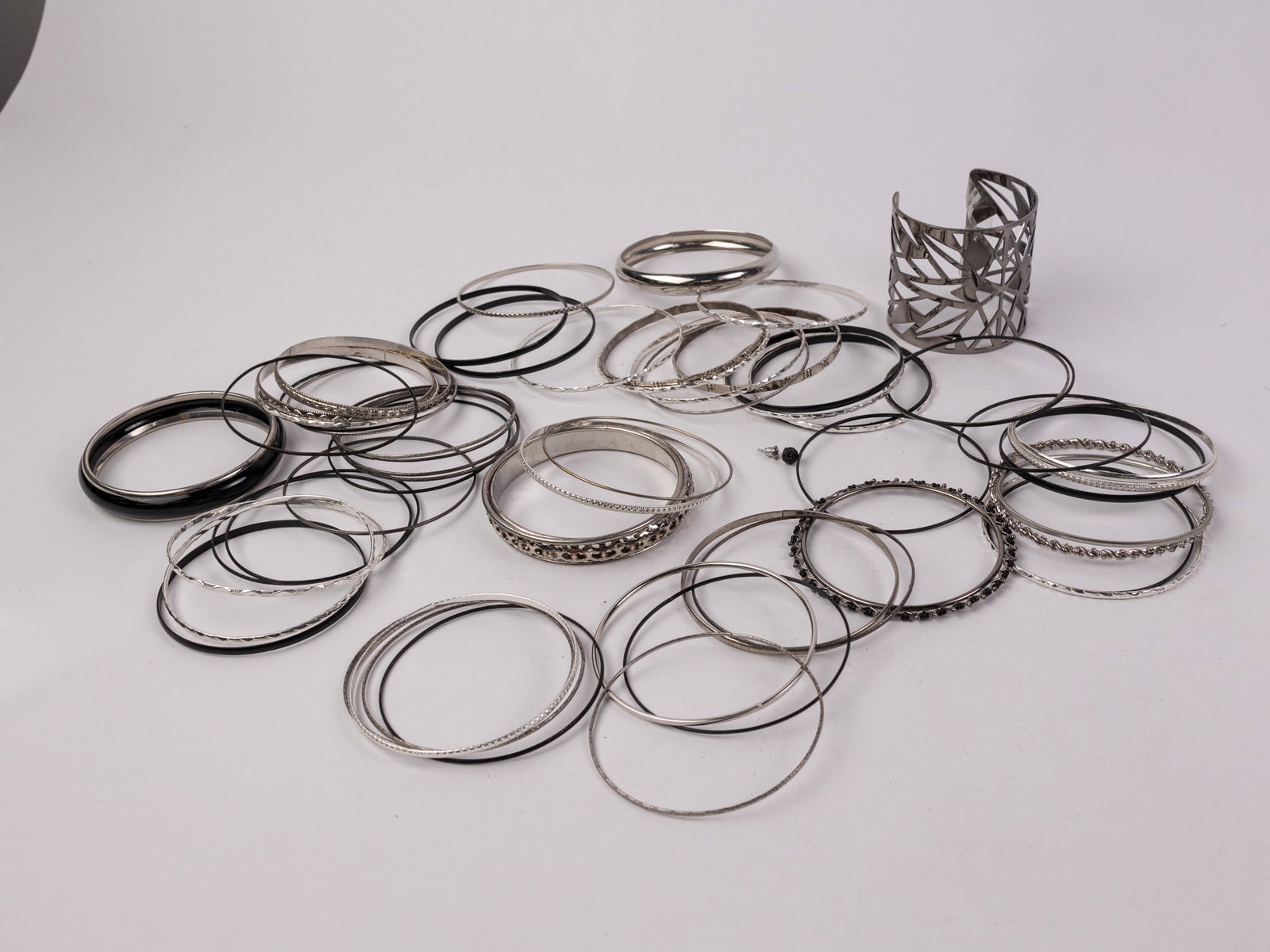 Assortment of Black and Silver-Tone Bangles, Cuffs and Bracelets: Assortment of Black and Silver-Tone Bangles, Cuffs and Bracelets Literature Brooks Auction – Online Auction Terms & Conditions Contact: (856) 694-2960 | info@brooks.auction READ BEFORE YOU BID: