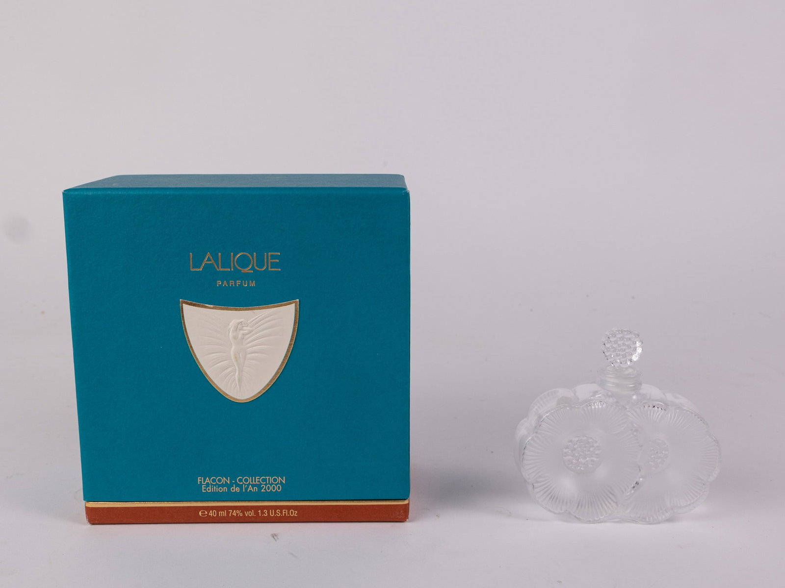 Lalique "Two Fleurs" Perfume Bottle with "Sylphide" Box: Known for their elegant stylized glass artwork, Lalique is a French glassware design house founded by artist, master ceramist and jeweler René Lalique that has operated since 1888. This piece, a 