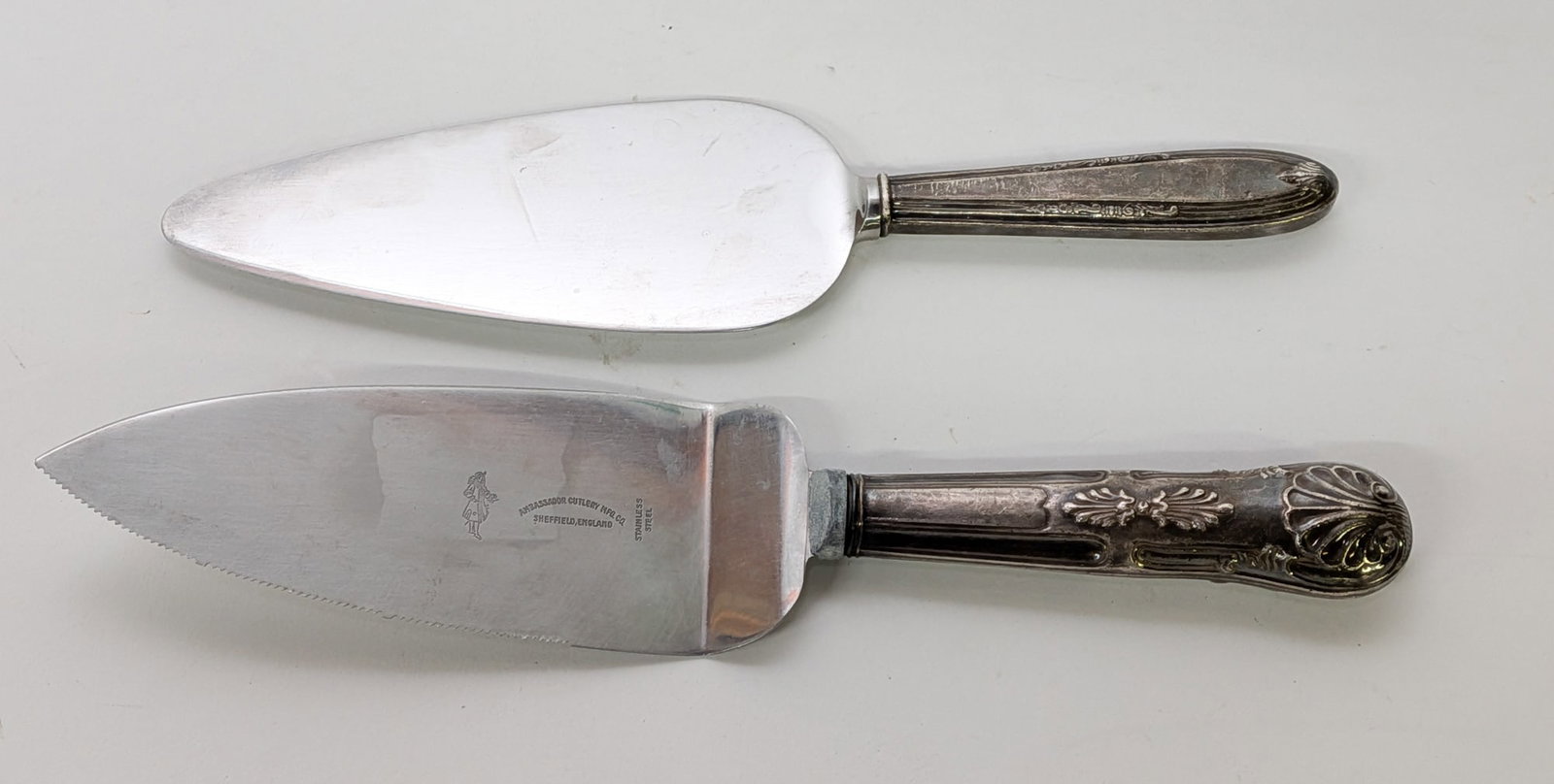 Pair of Vintage Sterling Silver Cake Servers: Marked "Sterling", Stainless blades, Total weight is 225.4 grams Literature Brooks Auction – Online Auction Terms & Conditions Contact: (856) 694-2960 | info@brooks.auction READ BEFORE YOU BID: