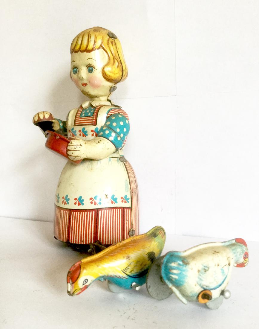Girl Feeding Chickens Wind Up Toy, 1950s: Girl Feeding Chickens Wind Up Toy. Tin Litho. Trademark T.P.S. Made in Japan, 1950's. 5" tall x 5 1/2" wide with Chickens x 2 1/2" deep Please note that this lot has a confidential reserve. When you l