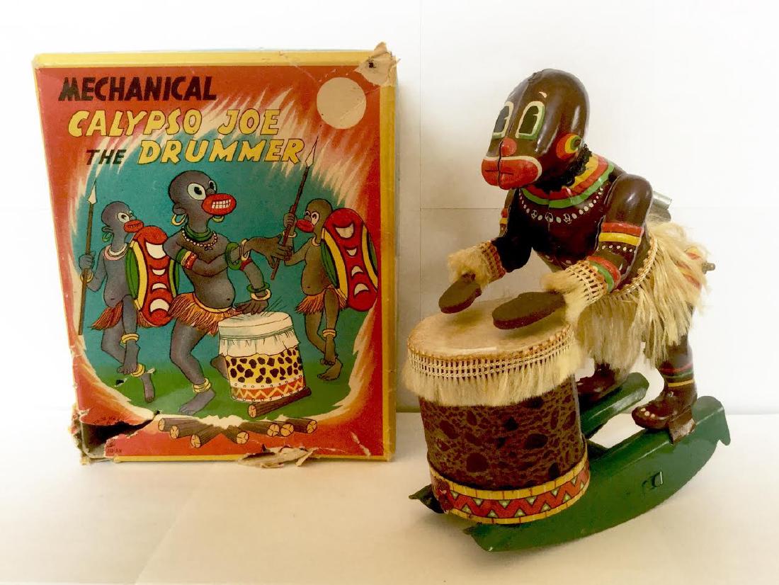 Mechanical "Calypso Joe the Drummer" Wind Up Toy: Mechanical "Calypso Joe the Drummer" Wind Up Toy Tin Litho with Fringe Skirt and Drum Decoration Original Box has damage Excellent Working Condition Japan, 1950's 6 1/2" tall x 2 1/4" wide x 4 1/2" de
