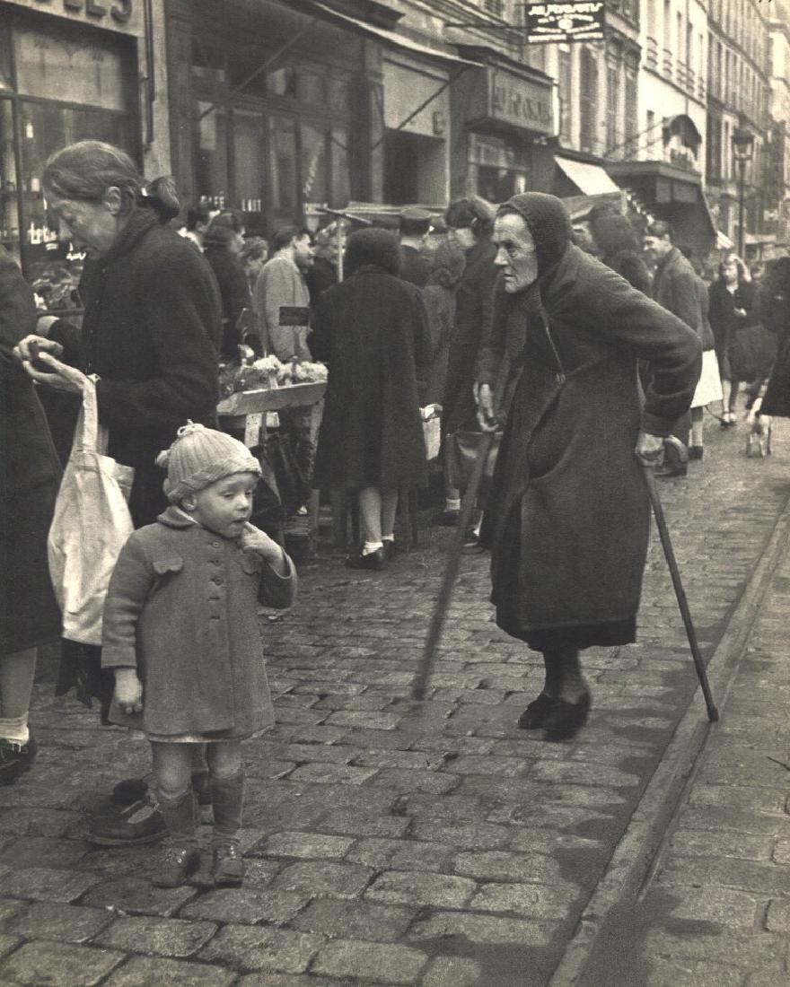 WILLY RONIS - Shopping, Rue de Menilmontant: Artist: WILLY RONIS Print Title: Shopping, Rue de Menilmontant Printing Date: 1954Medium: Sheet-fed Gravure Printed by Braun et Cie in France Image Size approx. 8" x 10" Willy Ronis (1910-2009) was a