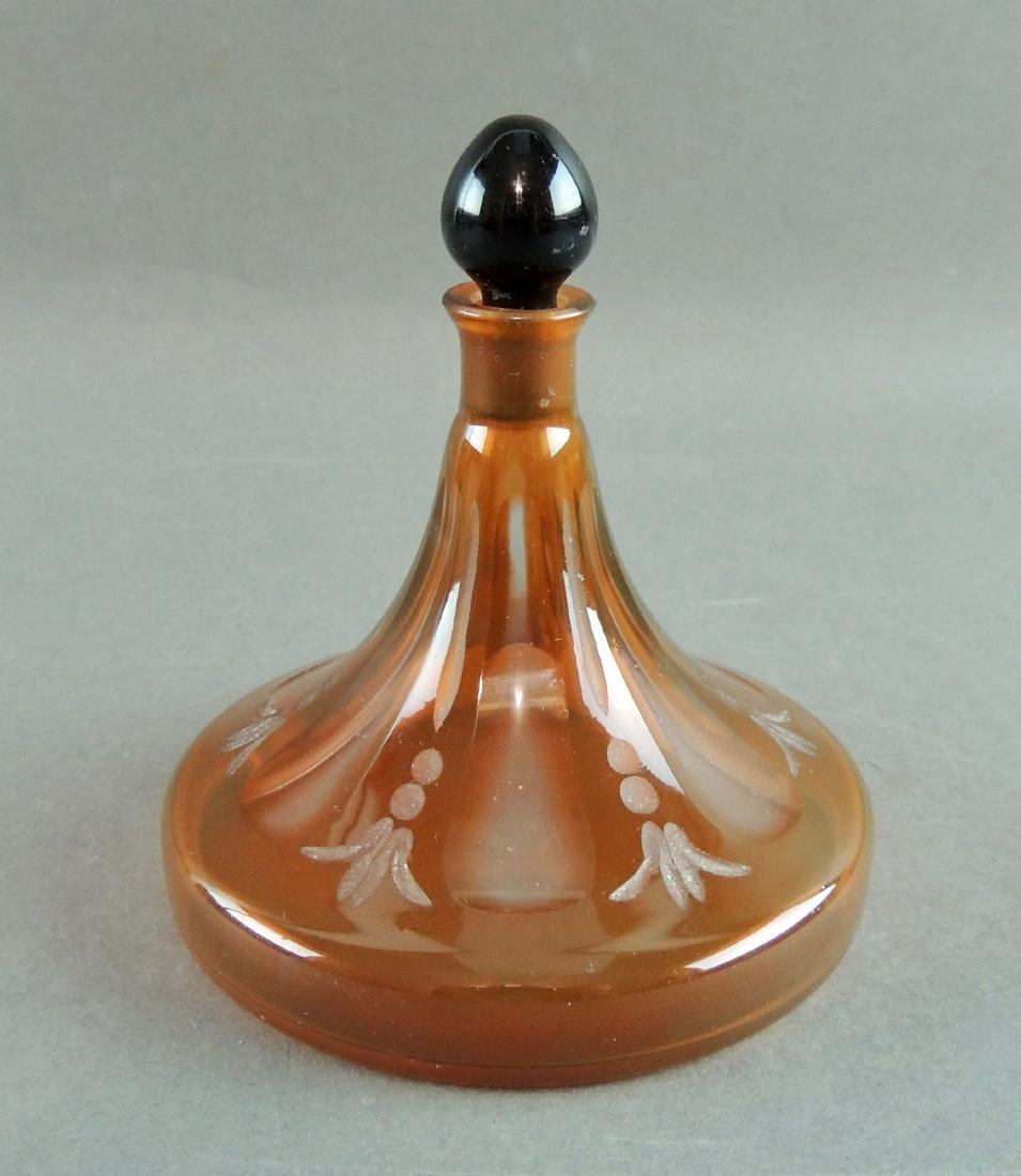 French Intaglio Perfume Glass Bottle: French Intaglio Perfume Bottle in frosted orange amber with black glass stopper. Incised mark on base made in France. Size: 3.75" high x 3.5" widest base Please note that this lot has a confidential r