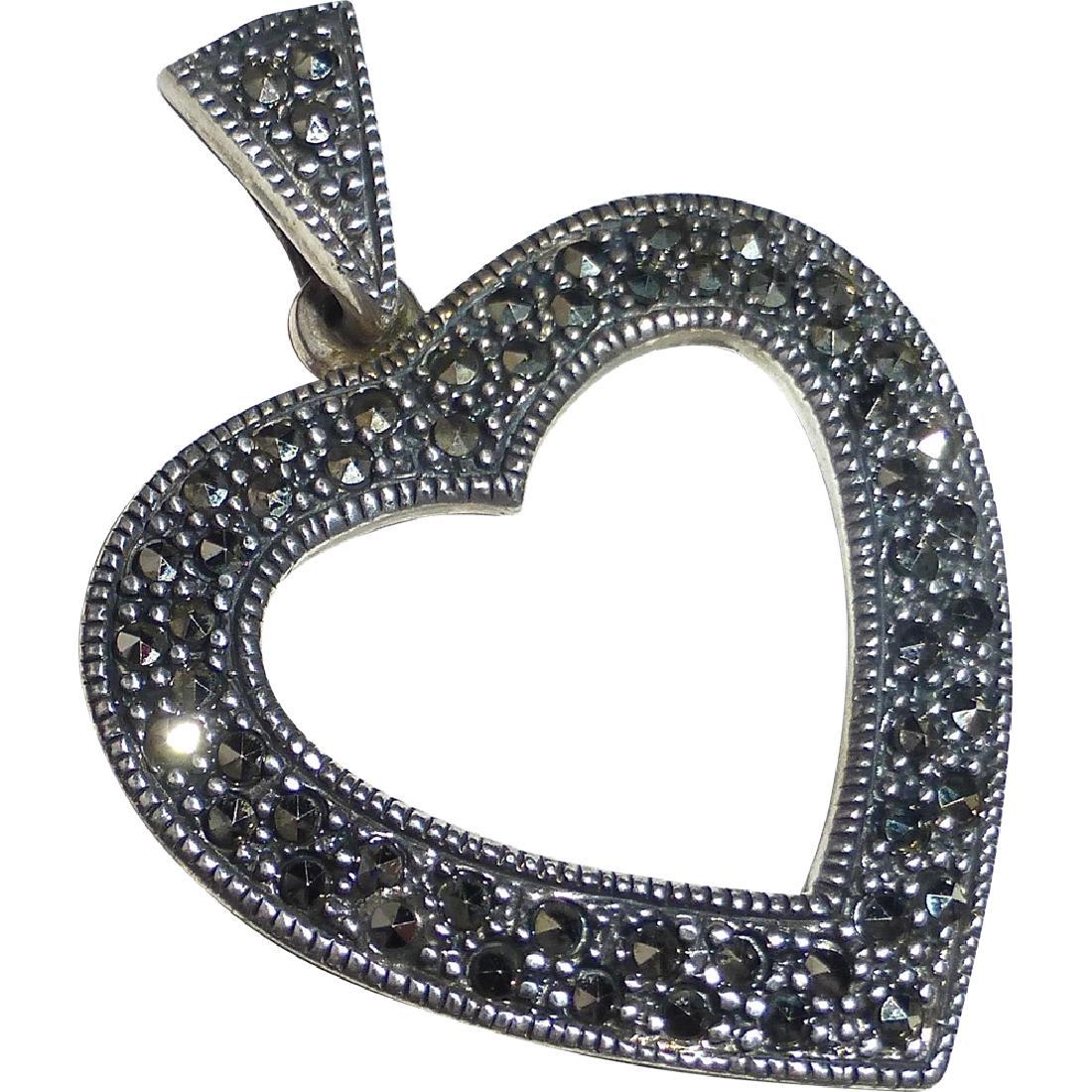 Sterling Silver Stylized Marcasite Heart Pendant: A lovely sterling pendant of a bold heart accented with sparkling marcasites. The classic heart has bead set marcasites alternating with raised silver dots, the edges have distinct millegrain. The hea