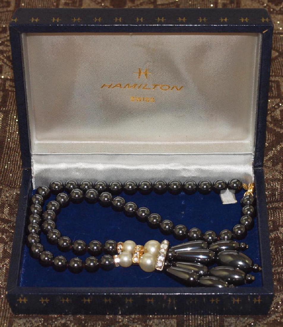 Vintage Hamilton Swiss Hematite Necklace: Wonderful necklace american style in hematite original, 1920s, with its original case marked “Hamilton Swiss”. It is made up of 50 hematite pearls in nylon thread, golden decorations with 24 cryst