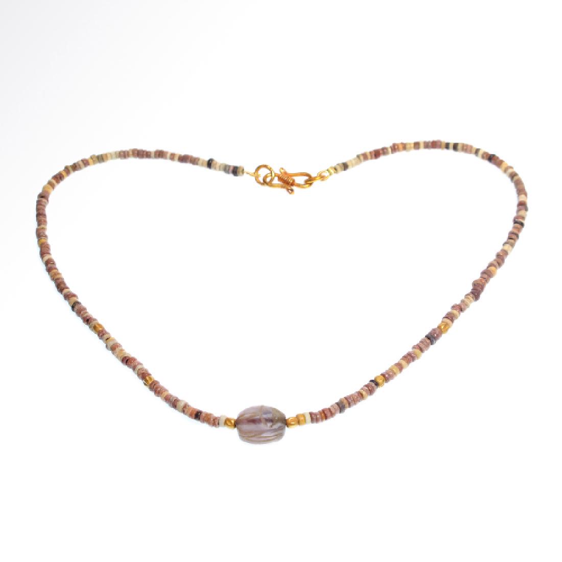 Egyptian Amethyst Scarab in Faience and Gold Beads: Date & Origin: Egypt, c. 300 B.C. Material: Faience, gold and amethist Dimension: 46 cm total L - 18 1/8 inches Provenance: English private collection Mr. A. Rehman, acquired in the 1980s. Composed of