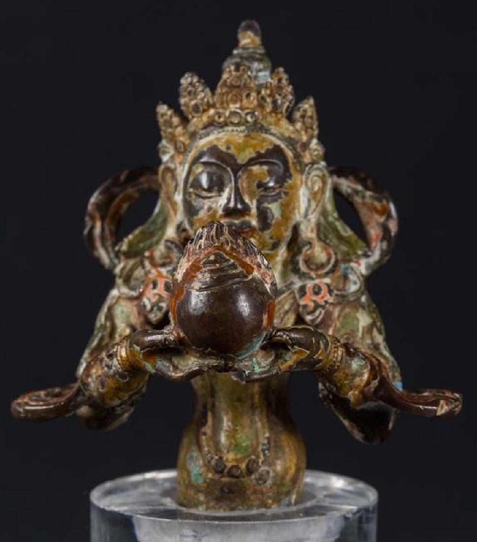 Nepalese Bust depicting a celestial being, 14th C: Item: Bust depicting a celestial being (Lokesvara?) Origin: Nepal Date: 14th century (Thakuri era) Materials: bronze colour on the surface Size: height 7 cm x 6 cm Small bust depicting an unidentified