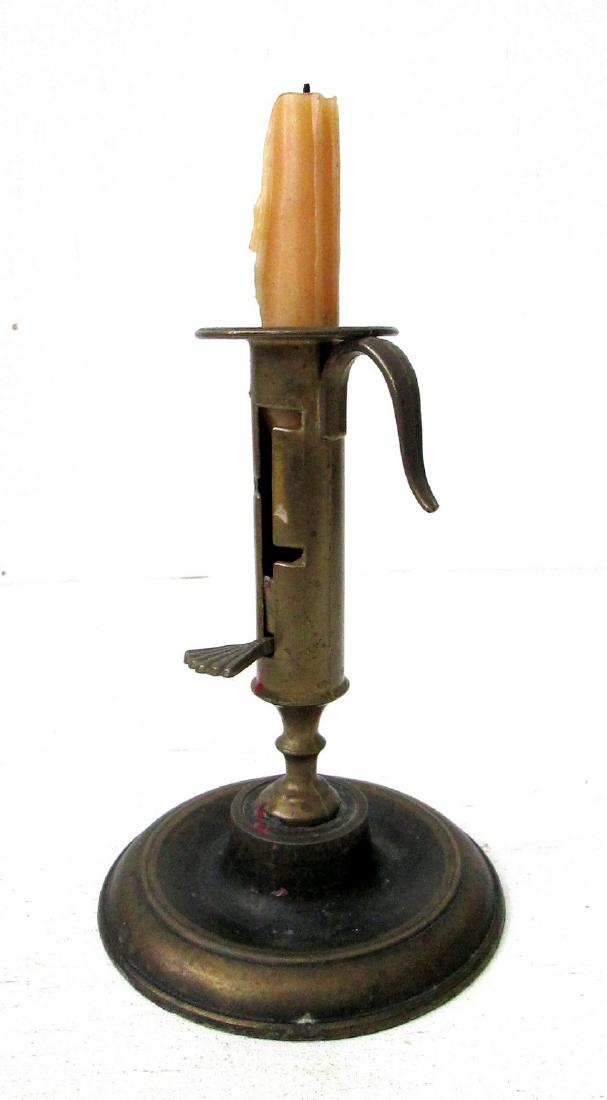 Early Brass Ratchet Candlestick: Early Brass Ratchet Candlestick Great form, unpolished old surfaces. Wide rim drip pan, above step notched double reel turned column, with scallop ribbed pushup handle, & dished, ribbed circular b