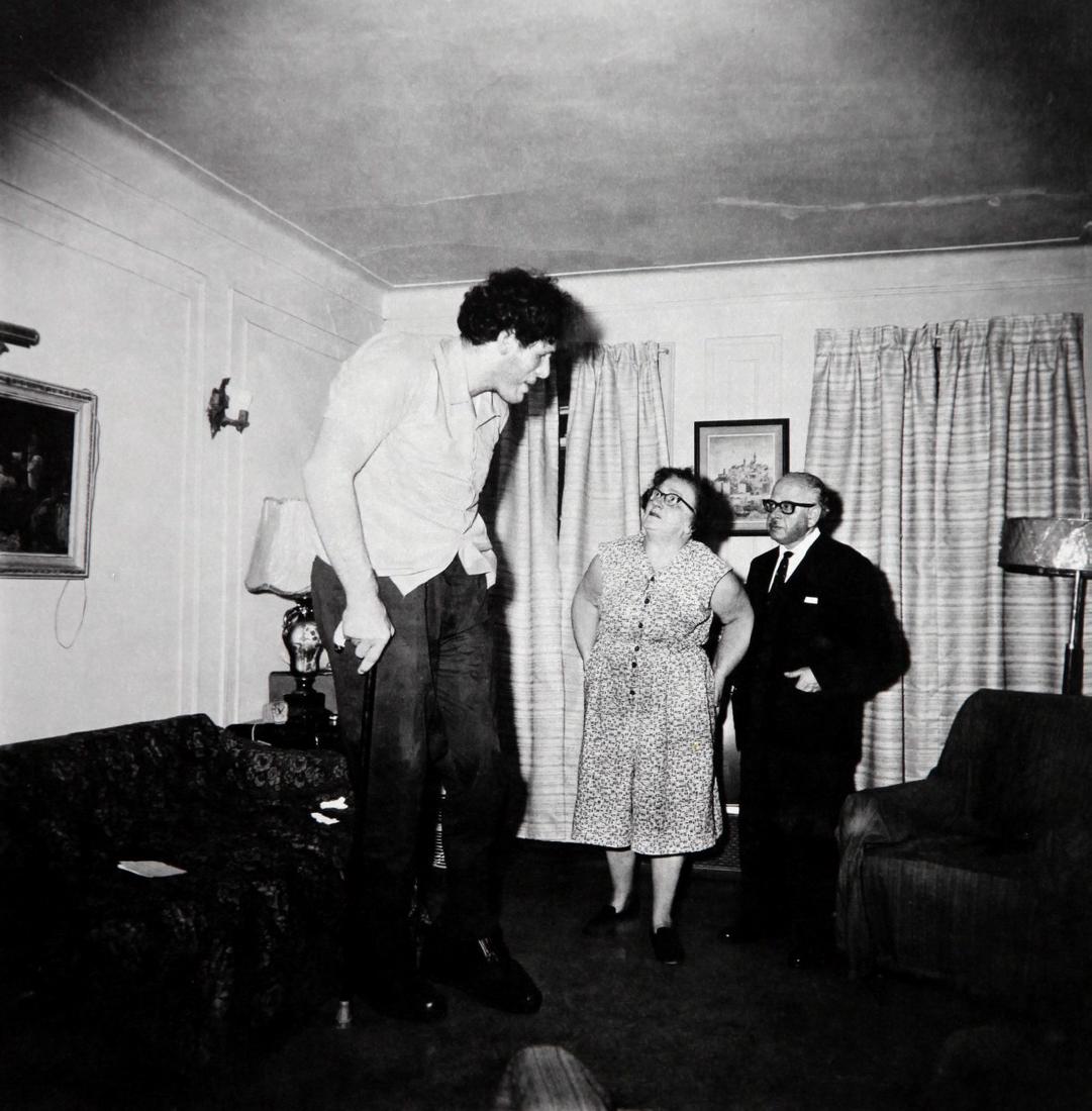 DIANE ARBUS - A giant at home with parents in the Bronx: Artist: Diane Arbus Title: A giant at home with parents in the Bronx 1970 Date Printed: 1979 Date Printed: Italy Printer Location: Milan Size: 25 x25 cm - 10x 10 inch, Mount Size: 30x40 cm - 15.7x11.8