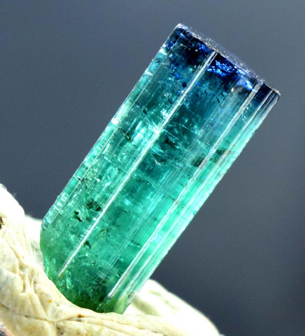 Terminated Blue Cap Tourmaline Crystal: Terminated Blue Cap Tourmaline Crystal Weight : 13.25 carats Size : 21*8*8 mm Treatment : Natural Origin : Paproke Afghanistan Standard DHL Shipping Please note that this lot has a confidential reserv