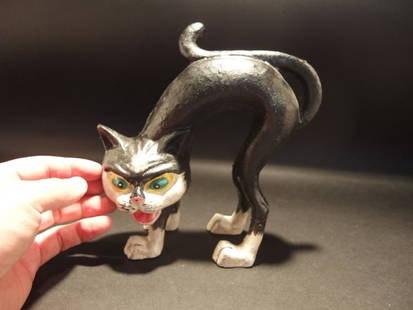 Cast Iron Scared Cat Door Stop: 7 1/2" Tall x 7 1/2" long Such a neat reproduction antique cast iron scared cat door stop. This heavy cast iron cat is all hand painted black and white with green and yellow eyes. As you can see this