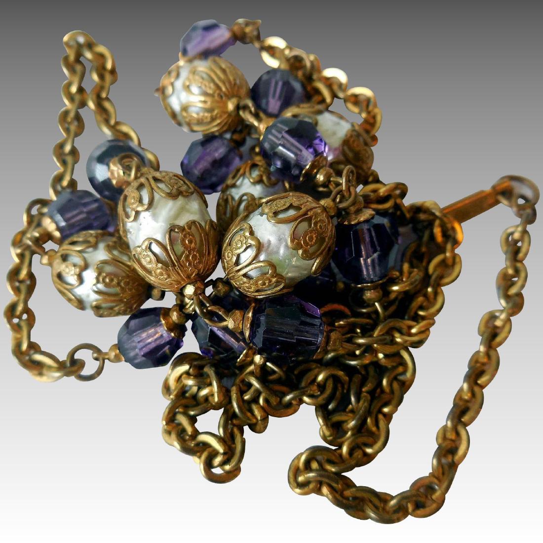 Miriam Haskell Matinee Length Necklace: Item: Miriam Haskell Matinee Length Necklace Maker: Miriam Haskell Origin: USA Date/Period: 1969 Materials: Gold-tone Metal, Faux Pearl, Amethyst Glass Size: 36 Inches around This is a matinee length,