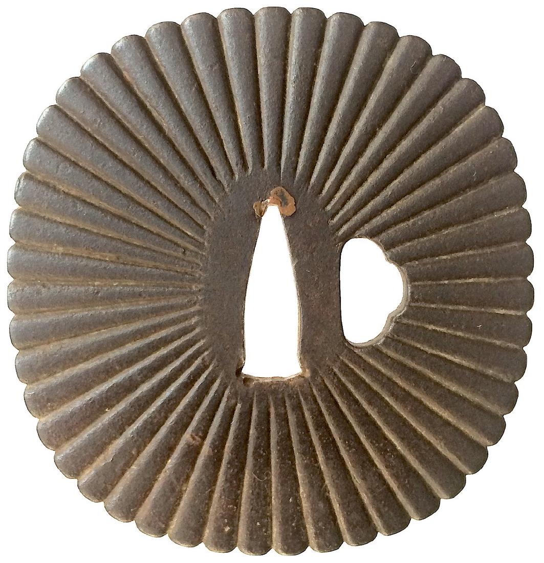 Large iron tsuba carved with chrysanthemum defign: Item: Large iron tsuba carved with chrysanthemum defign Origin: Japan Date: Edo period Materials: Iron Dimensions: 87.1 x 83.4 x 4.6 mm Iron tsuba of elongated rounded square form carved in low relief