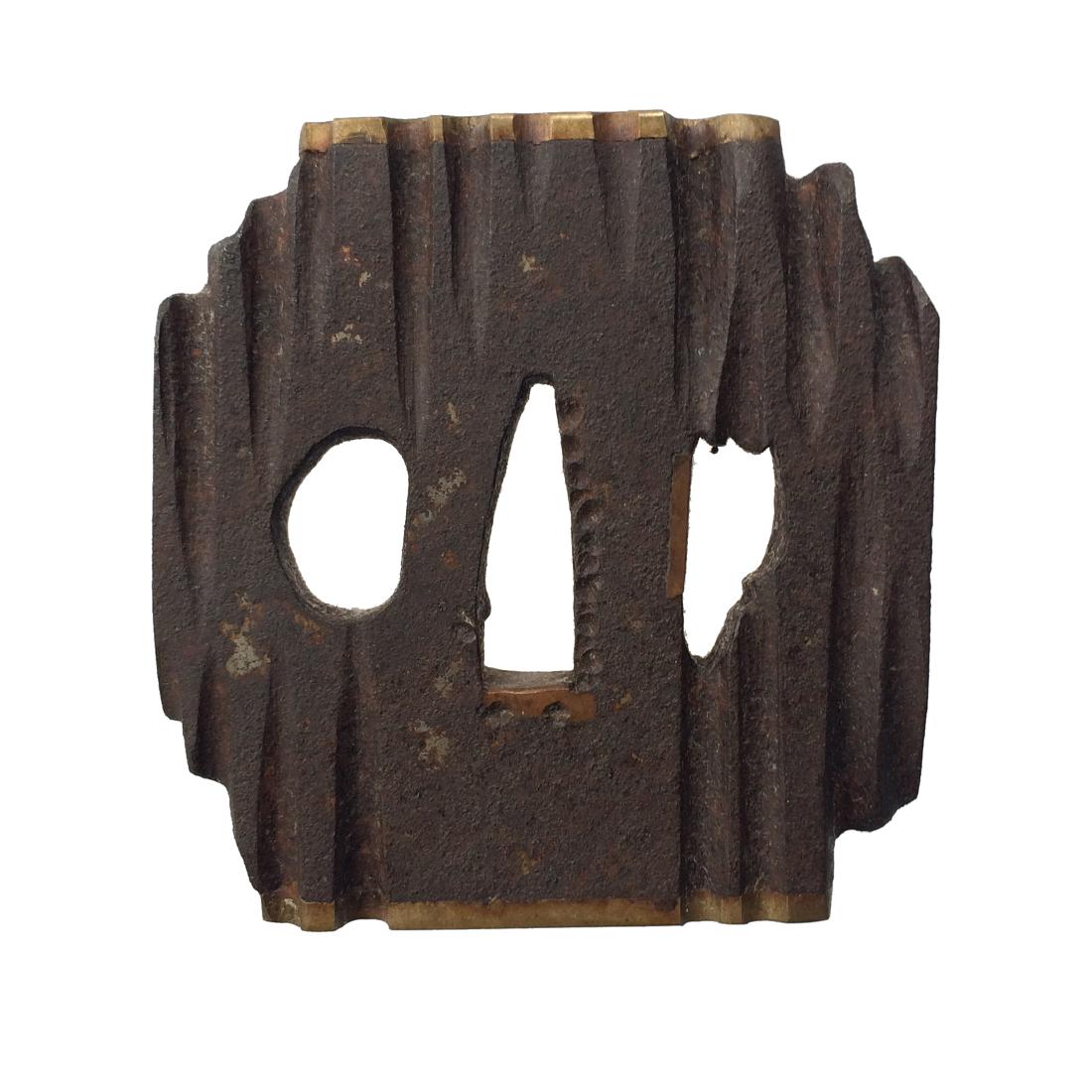 Iron tsuba imitating a piece of wood: Item: Iron tsuba imitating a piece of wood Origin: Japan Date: Edo period Materials: Iron Dimensions: 70.7 x 66.9 x 8.4 mm; 244 g Iron tsuba of irregular square form with rounded edges, with brass rim