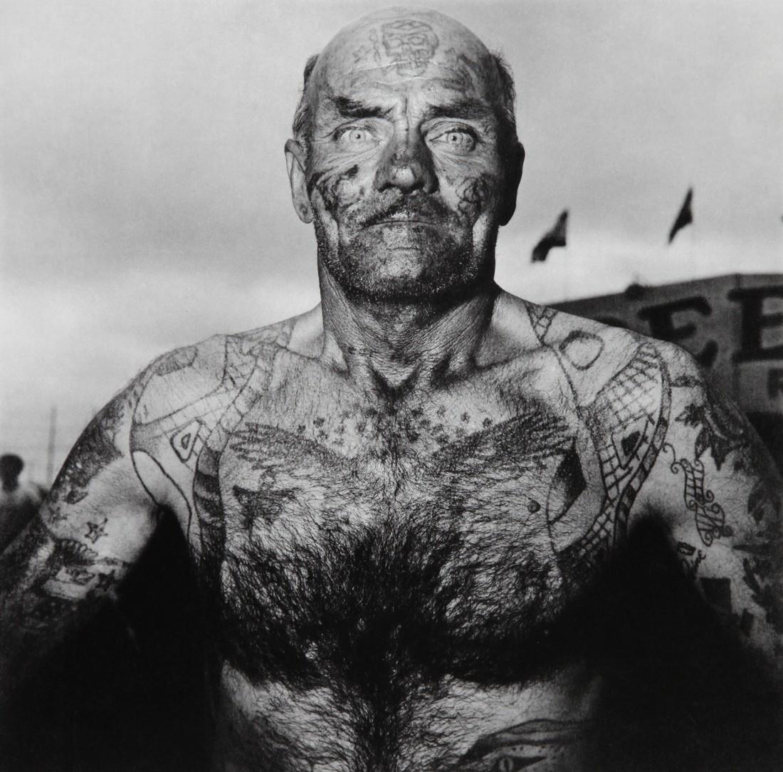 DIANE ARBUS - Tattoed Man at Carnival Maryland 1970: Artist: Diane Arbus Title: Tattoed Man at Carnival Maryland 1970 Date Printed: 1979 Heliogravure Printer Location: Electa Italy Size: 25 x25 cm - 10x 10 inch, Mount Size: 30x40 cm - 15.7x11.8 Inches D