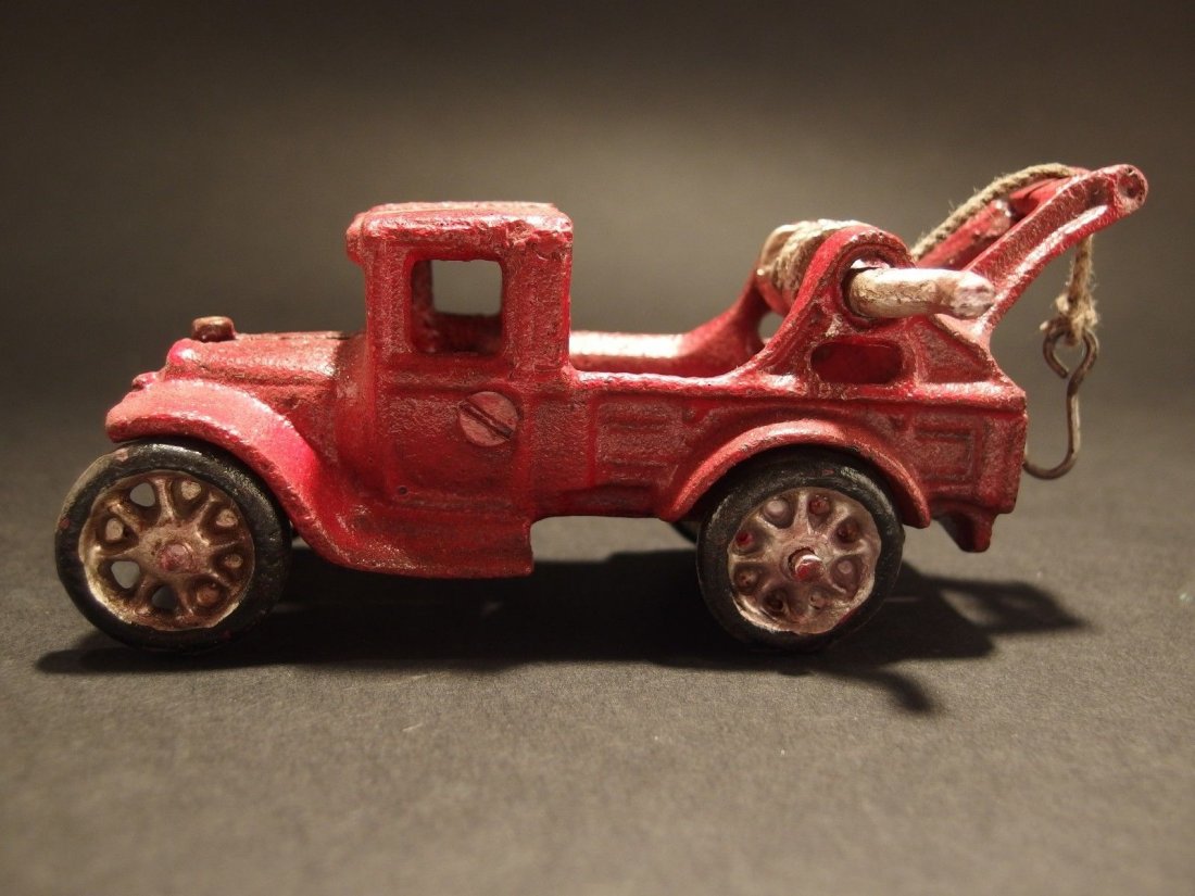 Cast Iron Red Tow Truck Toy Car: 5 1/4" Long x 1 5/8" Wide 2" Tall Such a neat reproduction cast iron car! As you can see this heavy cast iron tow truck was wonderfully hand painted and distressed to look original. The tow truck is m