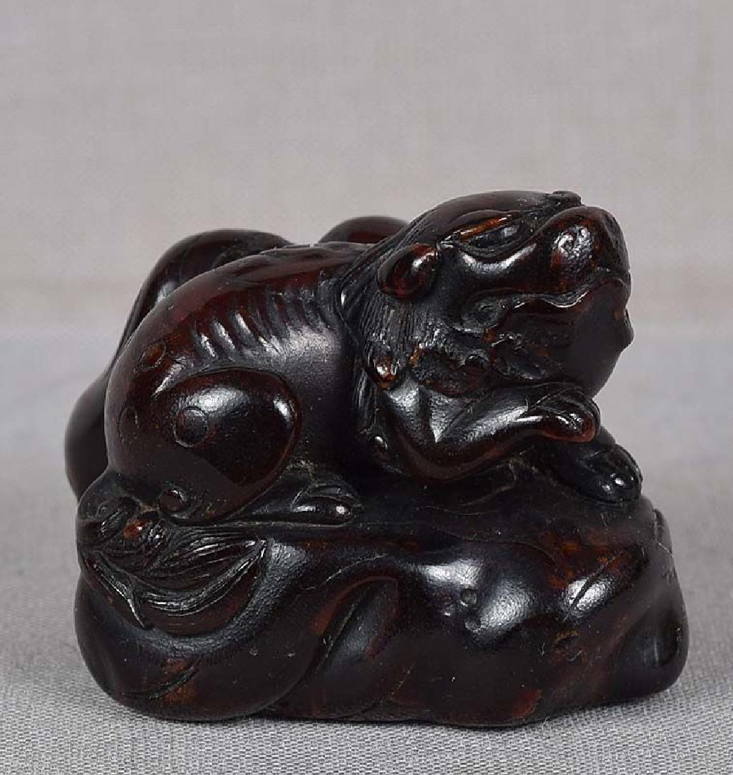 Early 19c umimatsu netsuke SHISHI on rocks: Rather unusual early 19th century netsuke depicting shishi (Buddhist lion) crouching on the rocks. The material is carved and polished umimatsu - in Japanese it literally means SEA PINE, and describes