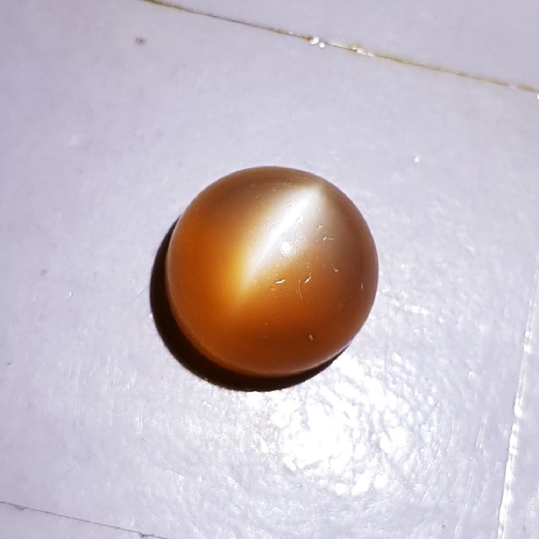 Orange Moonstone Cat's Eye - 9.70 ct: Item: Orange Moonstone Cat's Eye - 9.70 ct Loose gemstone Color/Clarity: VVS Carat Weight: 9.7 Size/Dimensions: 12.90 x 12.70 x 7.80 Round - India No Reserve: This lot starts at $1 and has no reserve