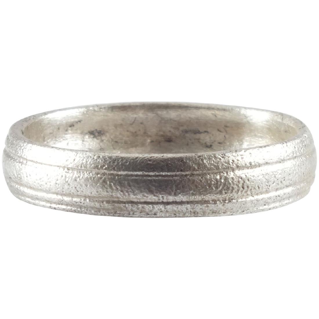 ANCIENT VIKING WEDDING RING C.850-1050 AD: Medium, round faced band with transverse linear ridges. Size 9. 19.3mm inner diameter. Band is 4.5mm wide. Fine patina. Vikings exchanged wedding bands on the pommel of the groom’s sword. Profession