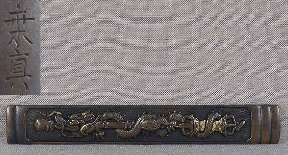 19c Japanese sword KOZUKA DRAGON on temple sword by: Early 19th century Japanese sword kozuka (sword knife) handle depicting a dragon wrapped around a temple sword with Buddhist thunderbolt handle, all on a punched ground. Excellently designed clever