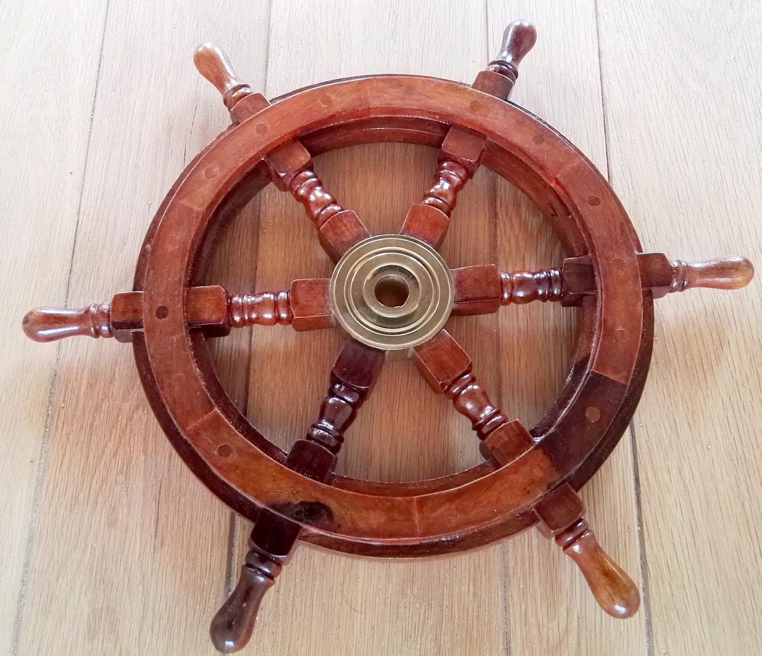 A wooden steering wheel of a boat: Item: A wooden steering wheel of a boat Maker: unknown Origin: France Date/Period: 20th century Materials: wood, copper Dimensions: Height: 46 cm, Width: 46 cm A beautiful wooden steering wheel of a b