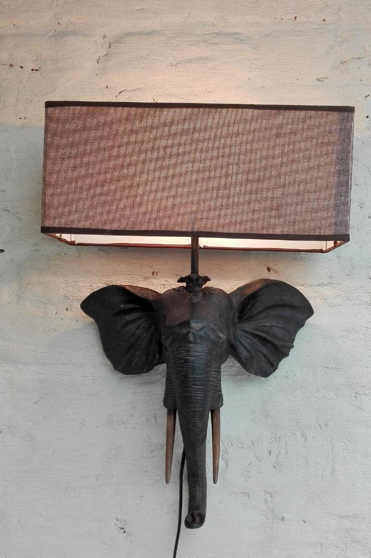 Wall light - elephants head: Item: Wall light - elephants head Maker: unknown Origin: Africa Date/Period: 21st century Materials: resin , fabric, Dimensions: Height: 52 cm, Width: 35 cm This is a beautiful lamp. Very decorating, 