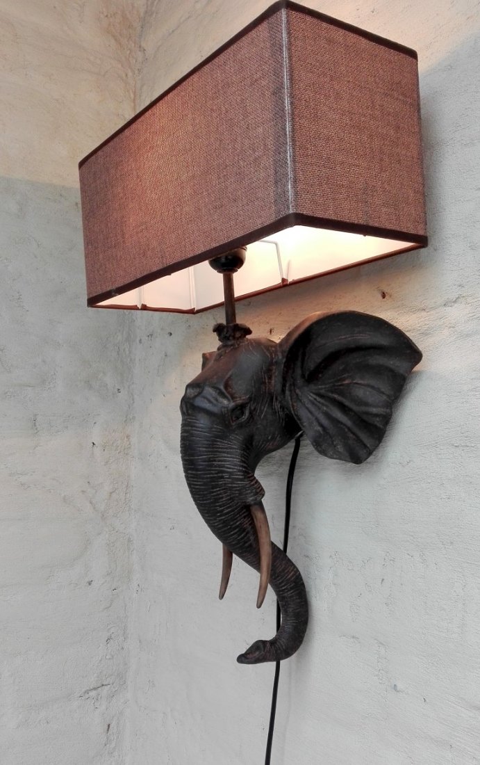 Wall light - elephants head: Item: Wall light - elephants head Maker: unknown Origin: Africa Date/Period: 21st century Materials: resin , fabric, Dimensions: Height: 52 cm Width: 35 cm This is a beautiful lamp. Very decorating, i