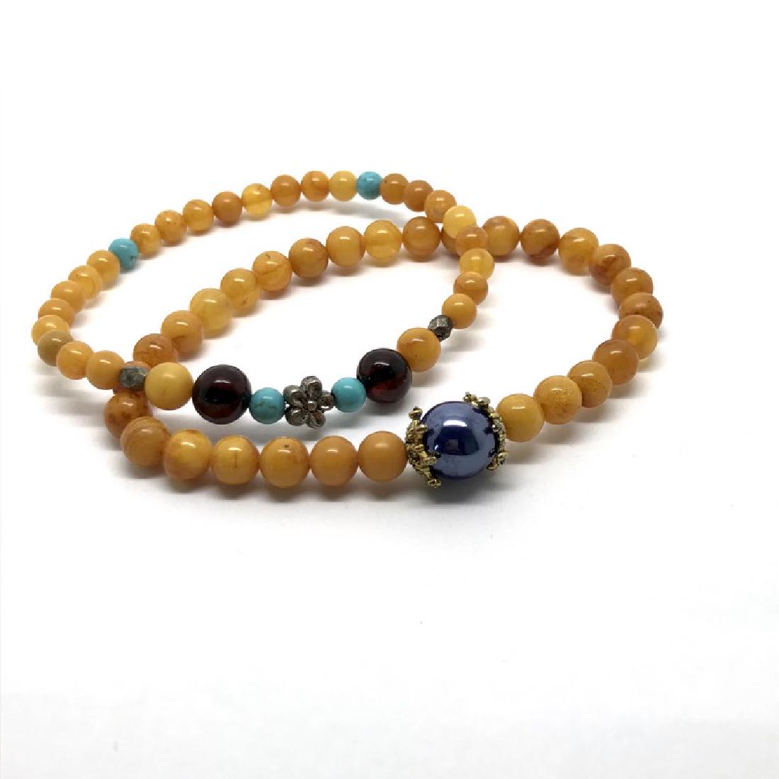 Two bracelets Baltic amber Turquoise: Title: Two bracelets Baltic amber Turquoise Metal: melchior Gemstones: Amber Weight: 9 grams Size: amber beads ø5-7.5mm, turquoise beads ø4,5mm, blue enamel bead ø9mm; 16 & 17cm in total Additional