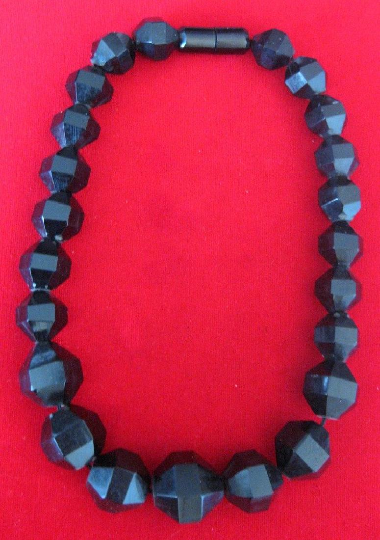 16-Inch Bakelite Choker from the 1930's: Bakelite Choker Circa. 1935 American Vintage bakelite choker in great condition. Graduated black faceted bakelite beads from 1/2 inch to 3/4 inch in diameter. with original barrel clasp. 16 inches lon