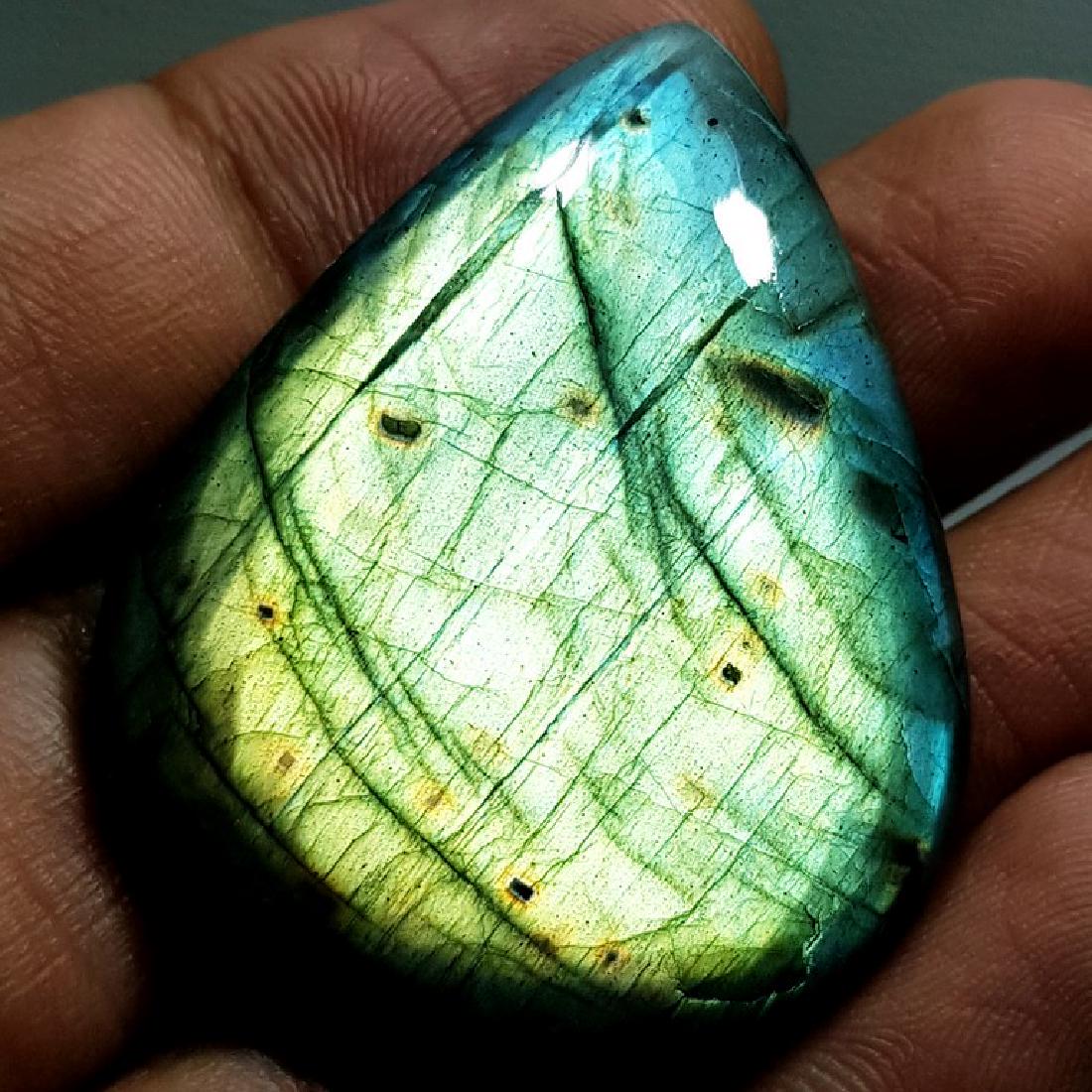 78.60 ct Natural Labradorite: No Reserve! Title: 78.60 ct Natural Labradorite Color/Clarity: Opaque Carat Weights: 78.6 Size/Dimensions: 43.58 x 34.66 x 7.01 Additional Information: Pear - USA Shipping: Worldwide: Flat-rate of $