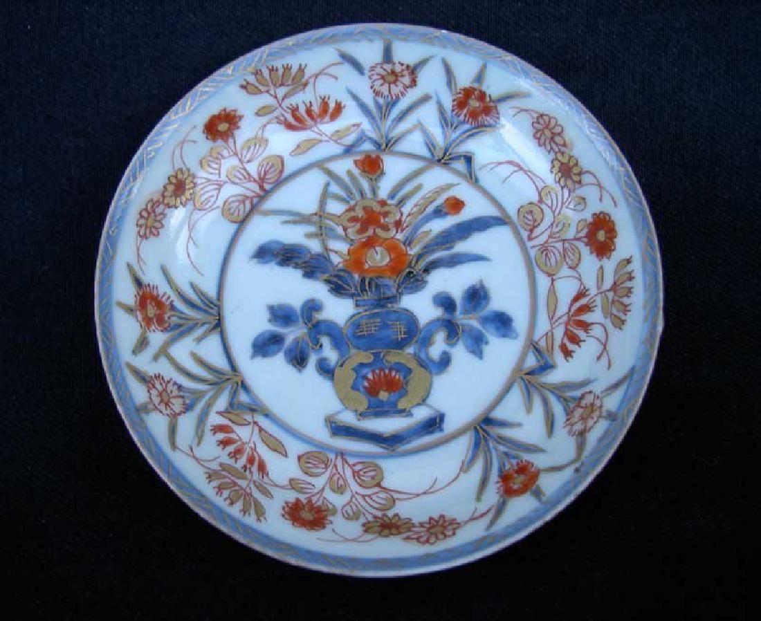 Pair of 18th c Japanese Imari dishes: Beautiful pair of small dishes or saucer plates, each with decoration in under glaze blue, iron red and gilt of a flower pot and surrounding flower stalks. Japan, Edo, 18th Century. Diameter "4¾/ 11,
