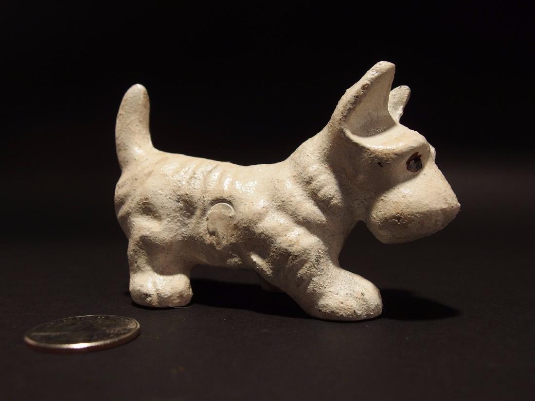 Cast Iron Scottish Highland White Terrier Westie Dog: 4" Long 2 1/2" Tall Such a neat reproduction of an antique cast iron terrier. This little figure is all cast iron hand painted and lightly distressed to look old. Minor nicks in the paint are common. 